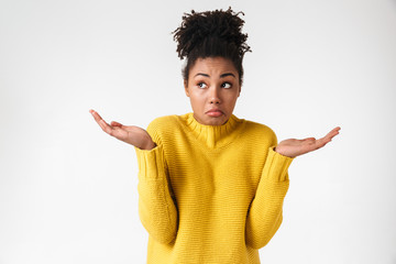 Beautiful young african confused woman posing isolated over white wall background.
