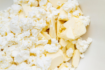 In a mixing bowl are the ingredients butter and cottage cheese for making cookies