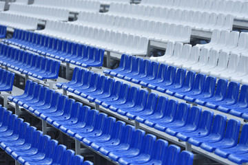 Empty stands with wet seats in red, white and blue in the stadium after the rain