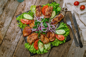 platter of different kebabs on wooden background