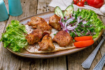 Kebab of pork on wooden background