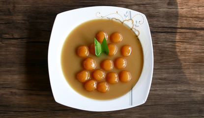 Biji salak on wood background. Biji salak is sweet potato dumplings with coconut sauce. Popular dessert in Indonesia or to break the fast.