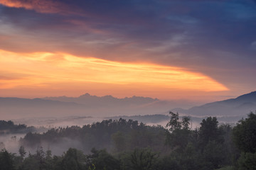 Obraz premium Sunset over the Alps on a foggy evening in Tunjice, Upper Carniola, Slovenia