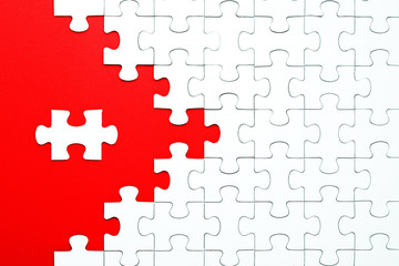 Fototapeta premium White puzzle pieces on a red background separated