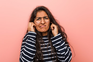 Young intellectual indian woman covering ears with his hands.