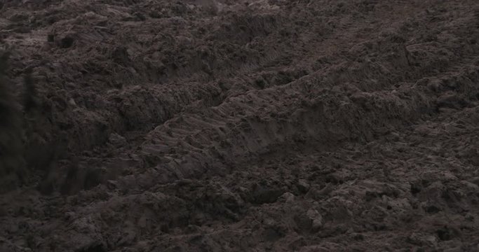 close shot of tracks from crawler moving through sand