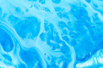 Abstract art texture background. Flowing emulsion design. Beautiful sky blue paint with bubbles and glitter.