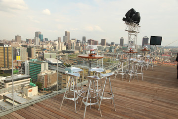 rooftop patio setup with furniture and city scape at the back