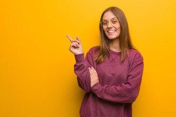 Young casual woman pointing to the side with finger