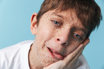 Portrait closeup of amusing beautiful boy 10-12y with freckles wearing white casual t-shirt smiling at camera