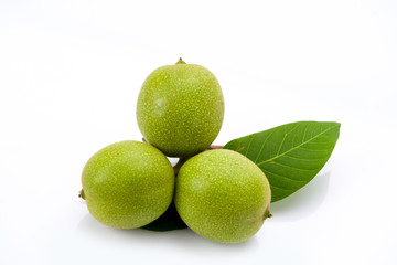 Young green walnuts with leaves isolated on white background. Vegetarian food.