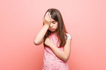 Cute little girl forgetting something, slapping forehead with palm and closing eyes.