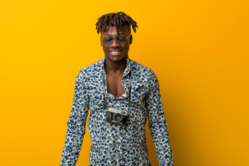 Obraz premium Young black rasta man wearing a vacation look laughs and closes eyes, feels relaxed and happy.