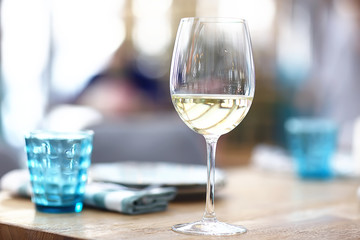 glass of white wine in the restaurant / white wine in the interior of the restaurant a table with glasses of wine, a romantic summer