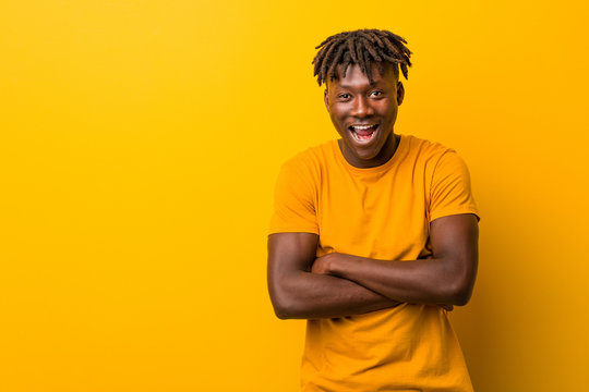 Young Black Man Wearing Rastas Over Yellow Background Laughing And Having Fun.