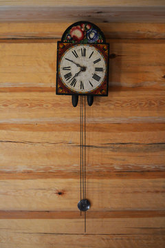 Reloj antiguo colgado en pared de madera.