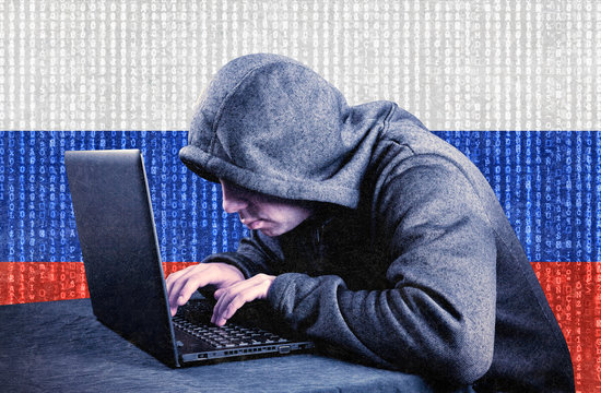 Russian hooded computer hacker with laptop 