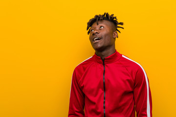Obraz premium Young fitness african man dreaming of achieving goals and purposes