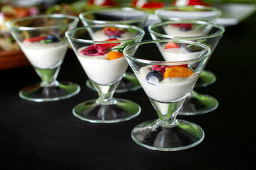 Creamy dessert with summer berries in a glass ice-cream bowl.