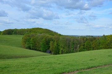 Hügellandschaft im Frühling mit Wolkenhimmel