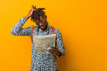 Young rasta black man holding a map being shocked, she has remembered important meeting.