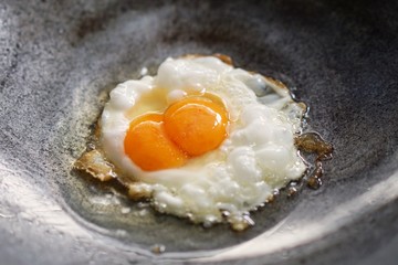 Double yolk eggs in frying pan. Thai style fried egg.