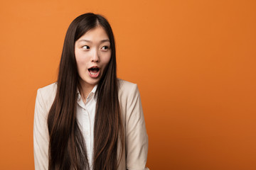 Young business chinese woman being shocked because of something she has seen.