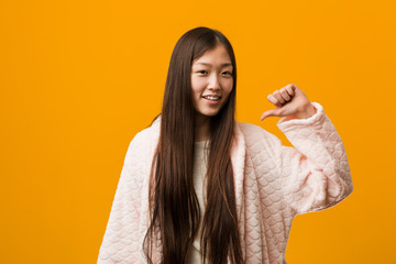 Young chinese woman in pajama feels proud and self confident, example to follow.