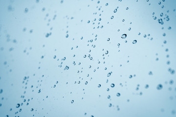Gouttelettes de pluie sur une fenêtre bleue