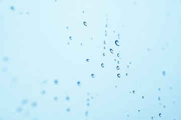 Gouttelettes de pluie sur une fenêtre bleue