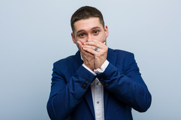 Young business caucasian man shocked covering mouth with hands.