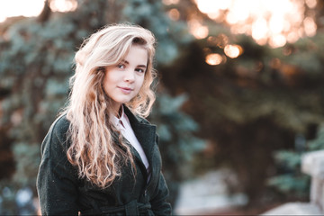Smiling teen girl 14-16 year old wearing stylish jacket over nature background. Looking at camera.