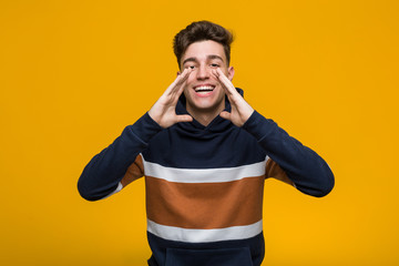 Young cool man wearing a hoodie shouting excited to front.