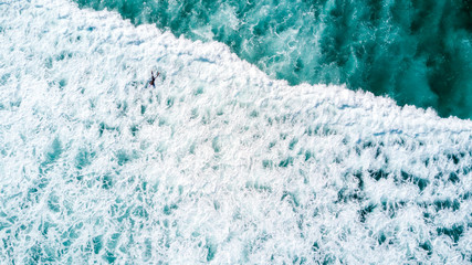 Surfers waiting for a good wave on sunny day. Muriwai Beach, Auckland, New Zealand
