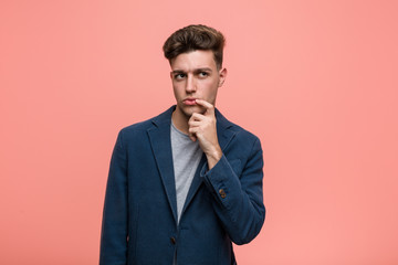 Young business natural man looking sideways with doubtful and skeptical expression.