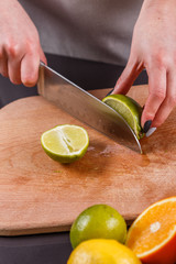 young woman in a gray aprons cut lime