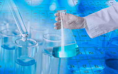 Scientist holding glass flask with liquid, closeup. Experimental chemistry