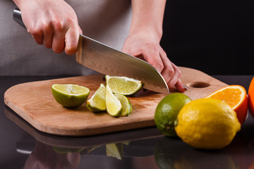 young woman in a gray aprons cut lime