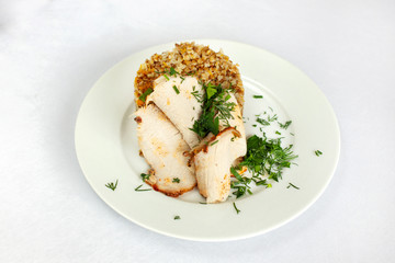 Chicken breast, buckwheat salad with greens on a white plate.
