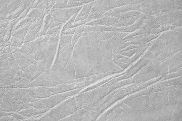 White skin texture, natural or faux leather background. Light gray leatherette, closeup.