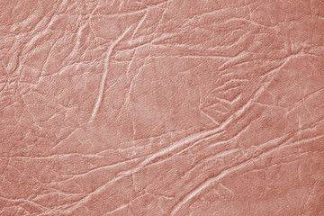 Light brown skin texture, natural or faux leather background. Pinkish leatherette, closeup.