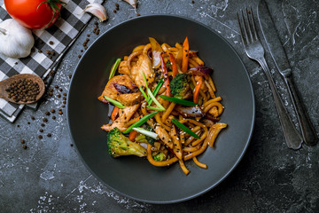 chicken wok noodles on black plate