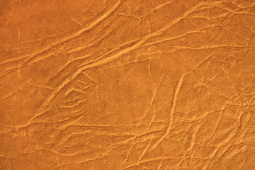 Brown skin texture, natural or faux leather background. Orange leatherette, closeup.