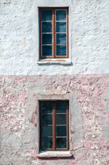 Fototapeta na wymiar Old vintage countryside house facade with two wooden windows closeup