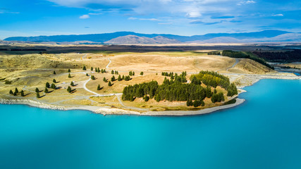 Road running through hills and forest with mountain range on the background. Otago, South Island,...