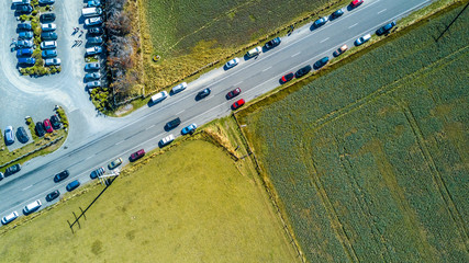 Cars parked along the road in the middle of a farmland. West Coast, South Island, New Zealand