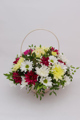 A bright bouquet of gerberas and chrysanthemums entwined with green sprigs of pistachio tree.