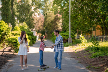 happy young family spending time in park on summer day