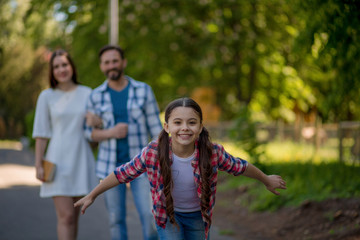 Fototapeta premium Smiling family with a skateboard in summer park