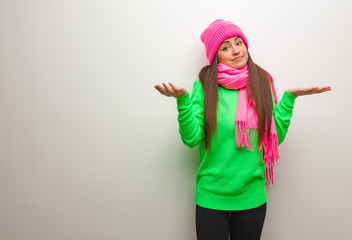 Young modern woman doubting and shrugging shoulders